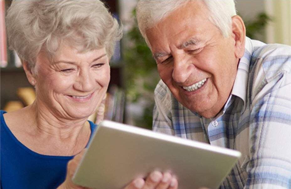 Two seniors look at a tablet together